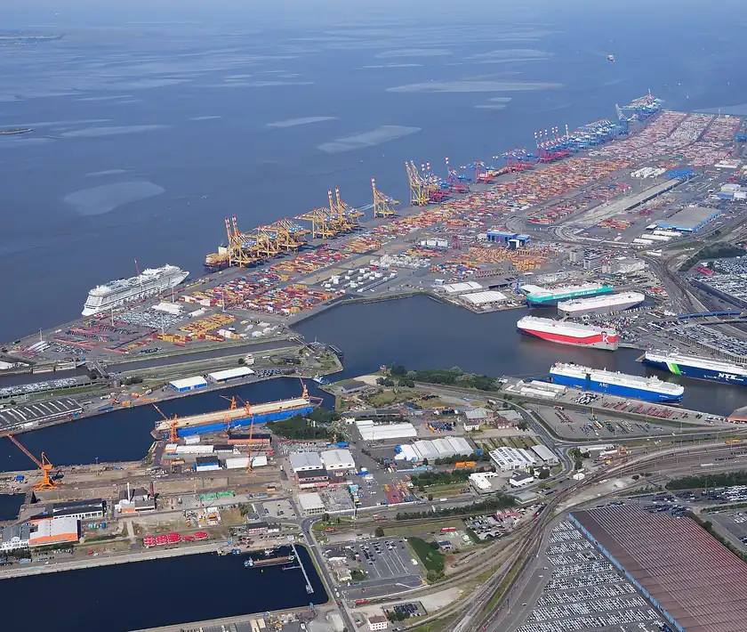 Aerial view of a container terminal with stacked containers and quay cranes